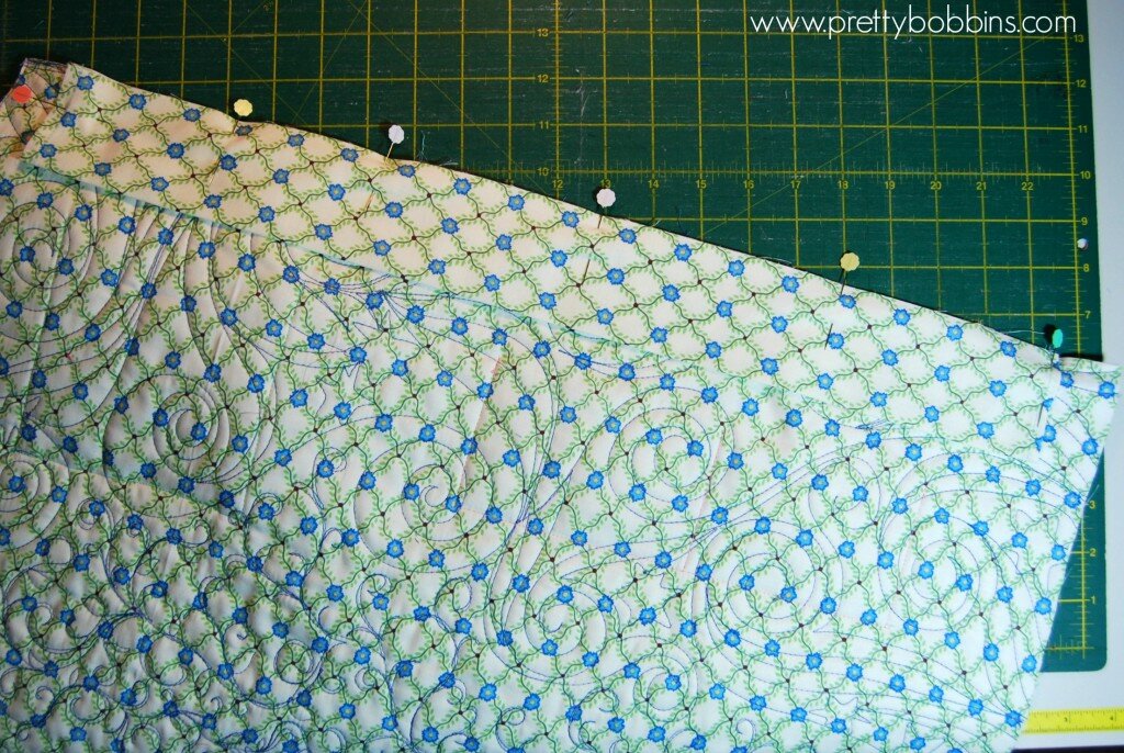 Line raw edge of hanging sleeve up with top raw edge of quilt